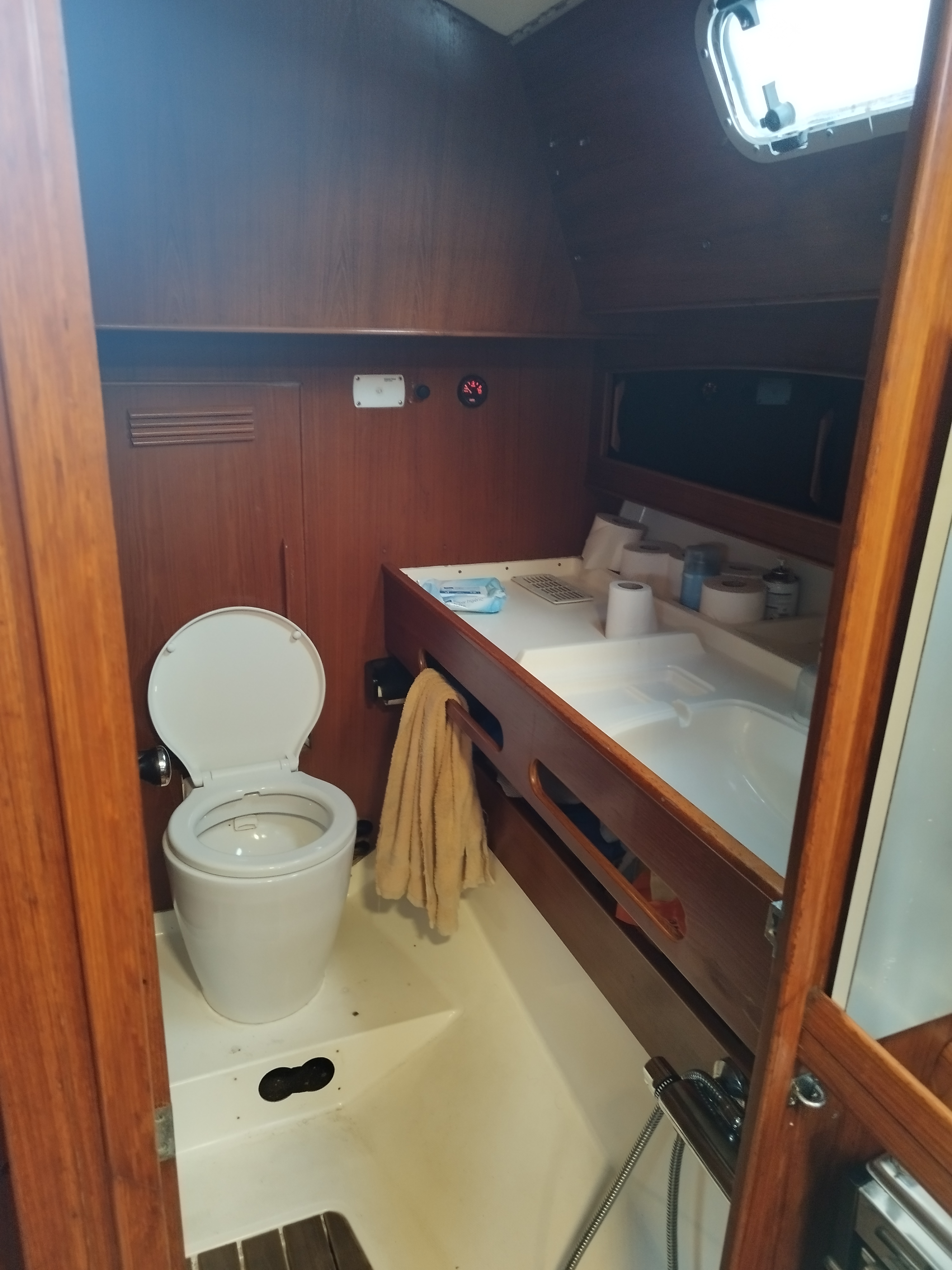 Privates Bad einer Segelyacht mit Toilette, Waschbecken und Handtüchern in einer Holzkabine