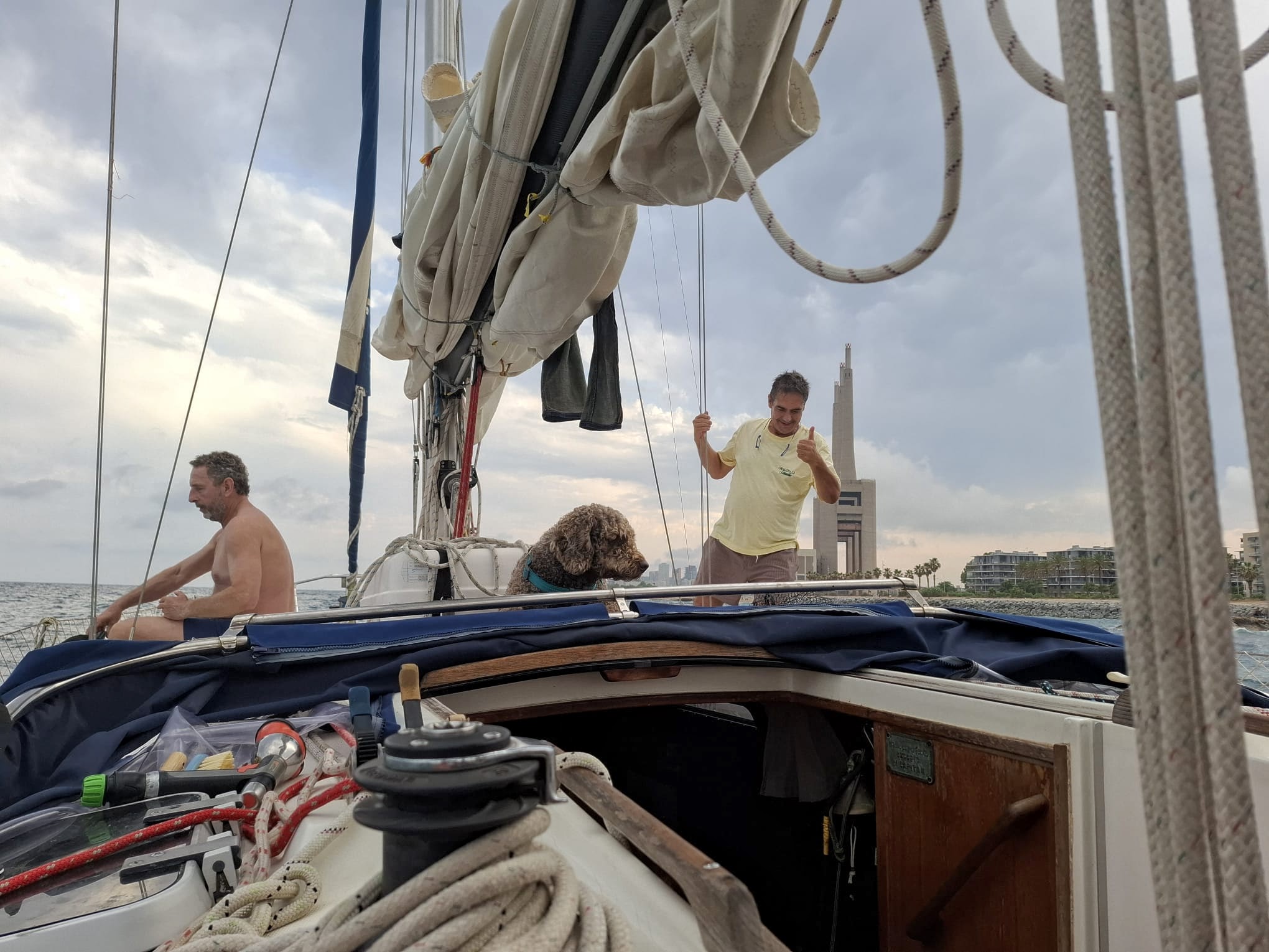 Grup gaudint a la coberta d’un veler privat navegant davant la costa de Barcelona