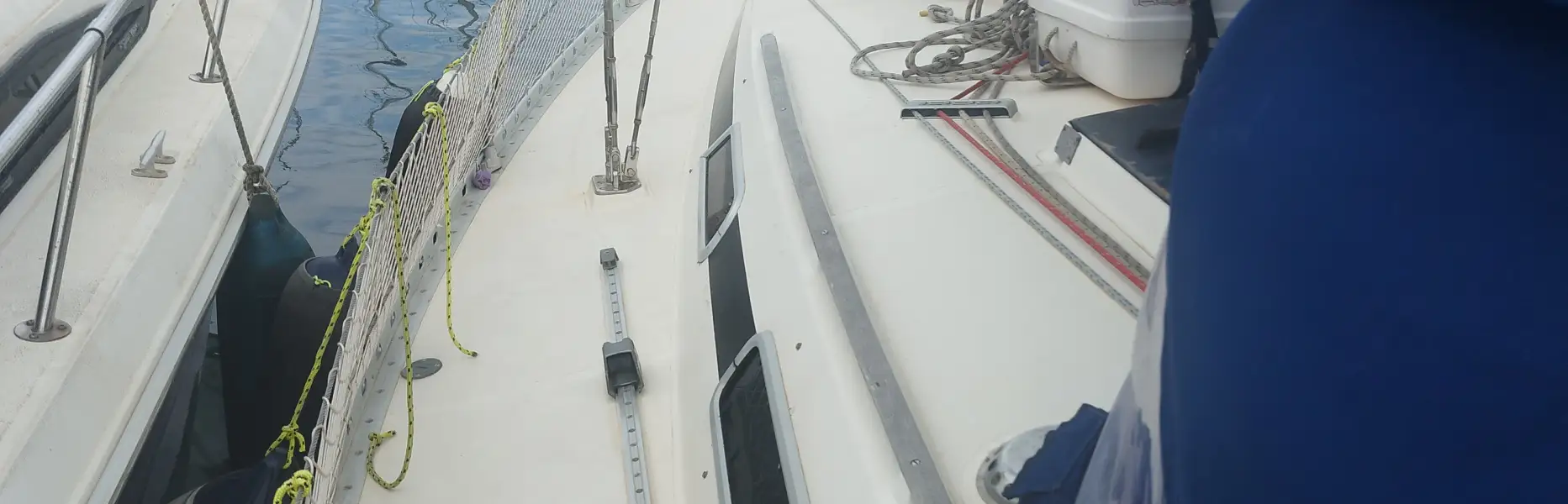 Vue du pont d’un voilier amarré dans un port de plaisance entouré d’autres bateaux