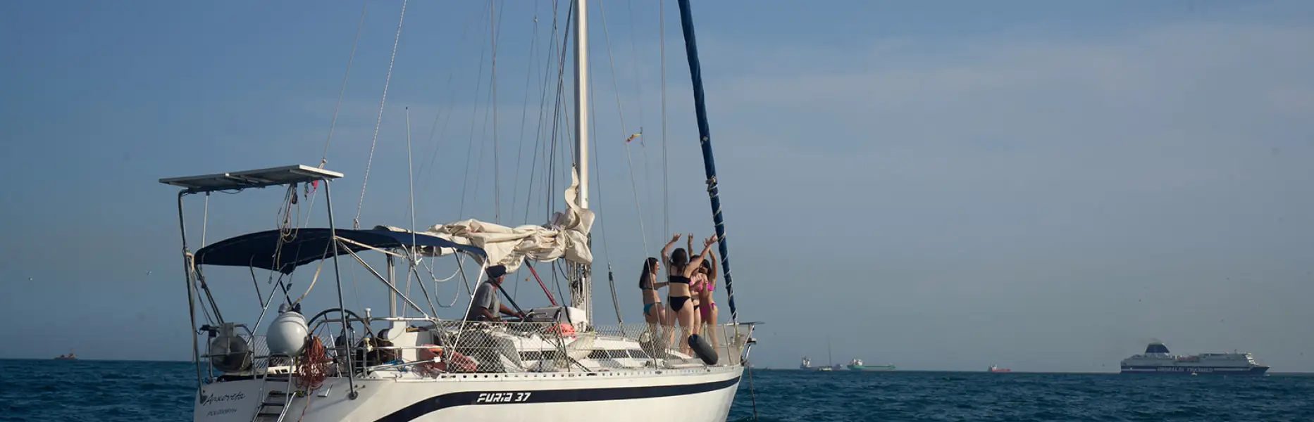 Velero de charter navegando en mar tranquilo con grupo de personas disfrutando a bordo