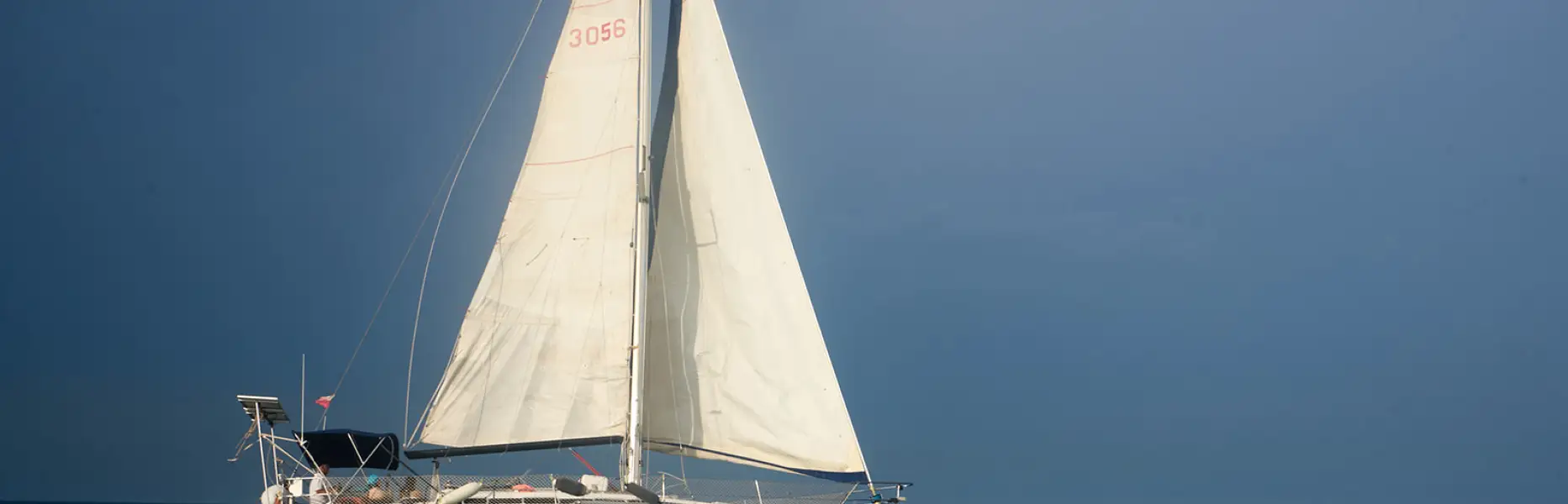 Velero de charter de vela blanca navegando en mar abierto sobre un mar tranquilo
