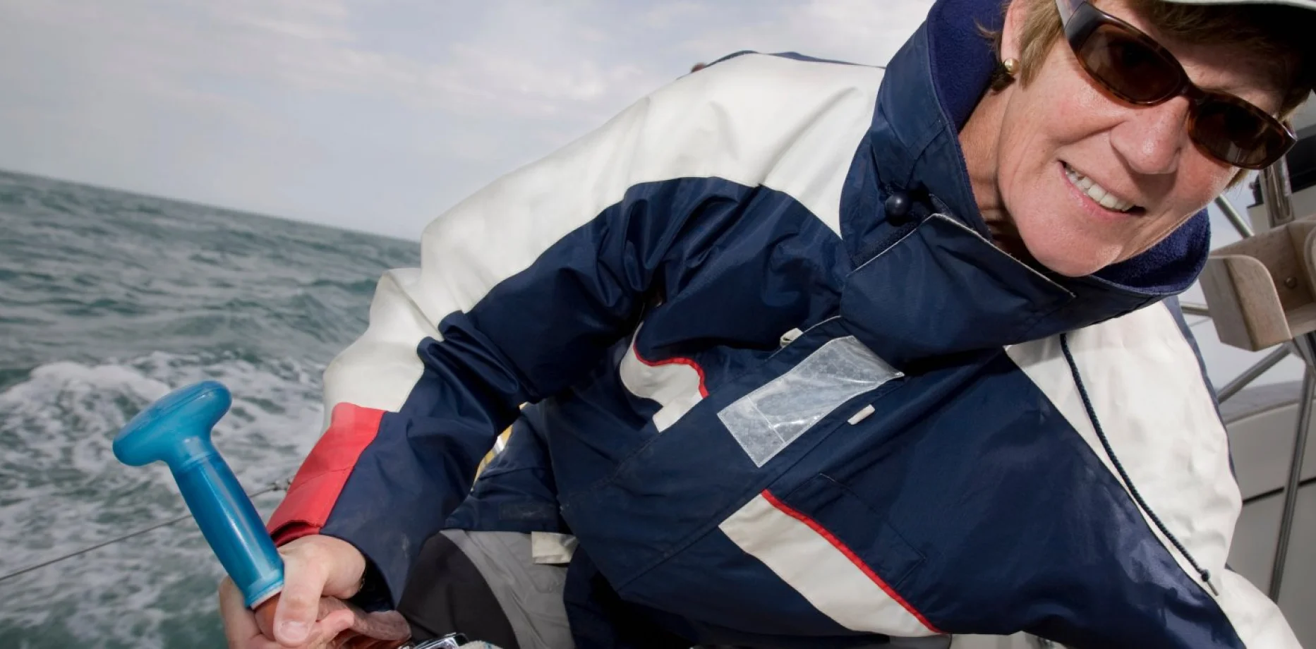 Grup de professionals gaudint de vi i aperitius en un veler davant l’skyline de Barcelona al capvespre