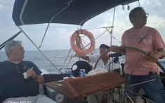 Grup d’amics navegant en veler privat amb patró professional al capvespre al Mediterrani