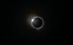 Fase de diamante del eclipse total de Sol con corona brillante sobre fondo negro