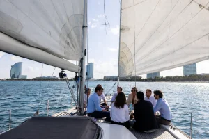Gruppo di professionisti in una riunione di lavoro a bordo di una barca a vela di fronte alla costa di Barcellona