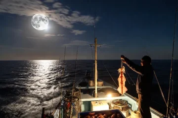 Nachtangeln auf dem Boot unter dem Vollmond