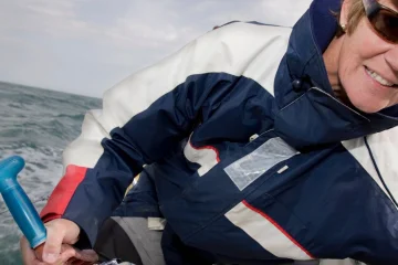 Donna che naviga una barca a vela a noleggio