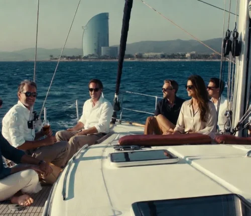 Grupo de amigos disfrutando de un charter de lujo en velero frente a la costa de Barcelona