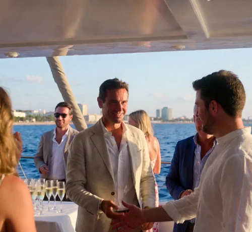 Groupe de personnes profitant d’un événement de luxe à bord d’un yacht charter au coucher du soleil face à la mer