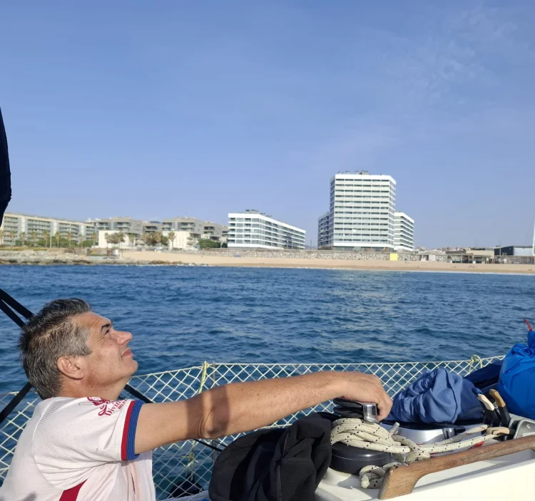 Skipper naviguant en voilier au large de la côte de Barcelone par une journée ensoleillée